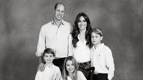 Schwarz-weiß Bild Eltern mit zwei Söhnen und einer Tochter stehen zusammen - Prinz William, Prinzessin Kate und Prinz George stehen hinten, Prinzessin Charlotte sitzt auf einer kleinen Bank davor und Prinz Louis steht links daneben