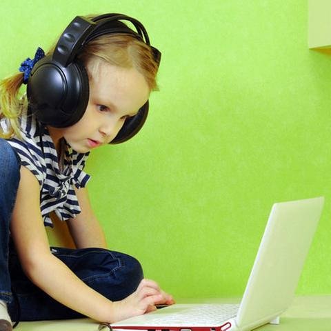 Kind mit Kopfhörern am Laptop