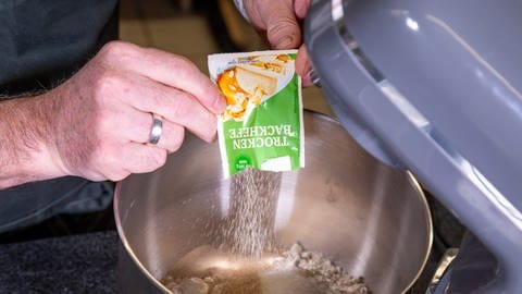 Trockenhefe wird in die Rührschüssel zum Mehl geschüttet: Um den Kassler im Brotteig im Backofen zuzubereiten, braucht es nach dem Rezept von SWR4 Konditor Joachim Habiger einen Hefeteig.