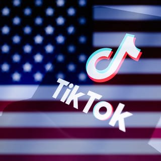 Das TikTok-Logo wird auf einem Smartphone vor dem Hintergrund der abgeschnittenen US-Fahne angezeigt. (Foto: dpa Bildfunk, picture alliance/dpa/ZUMA Press Wire | Andre M. Chang)