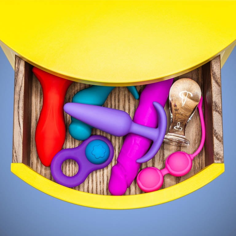 Verschiedene Sexspielzeuge in bunten Farben in einer Schublade zur vaginalen oder analen Befriedigung