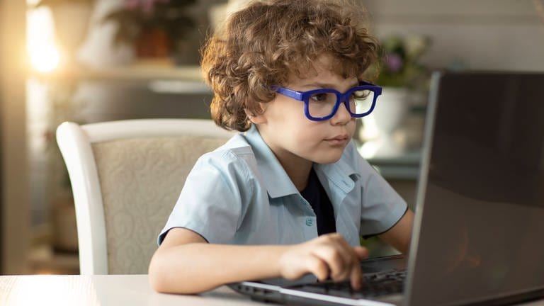 Junge mit Brille sitzt dicht vor einem aufgeklappten Laptop: Augenerkrankungen nehmen weltweit deutlich zu. Zwei Drittel aller Deutschen benötigen bereits eine Sehhilfe. Bei jungen Menschen steigt vor allem die Zahl der Kurzsichtigen.